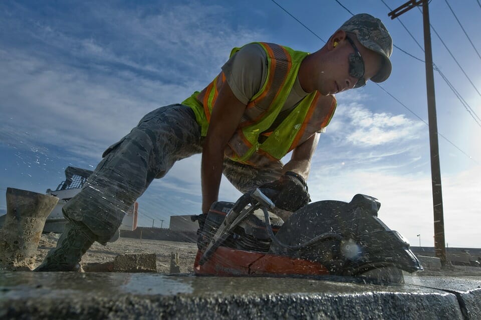 A construction worker cutting stone with a wet saw.