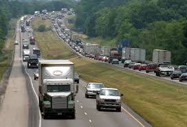 Crowded highway with many tractor trailer trucks