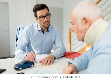 A lawyer sitting down with the victim of a personal accident, helping him figure out how his personal injury compensation is calculated.