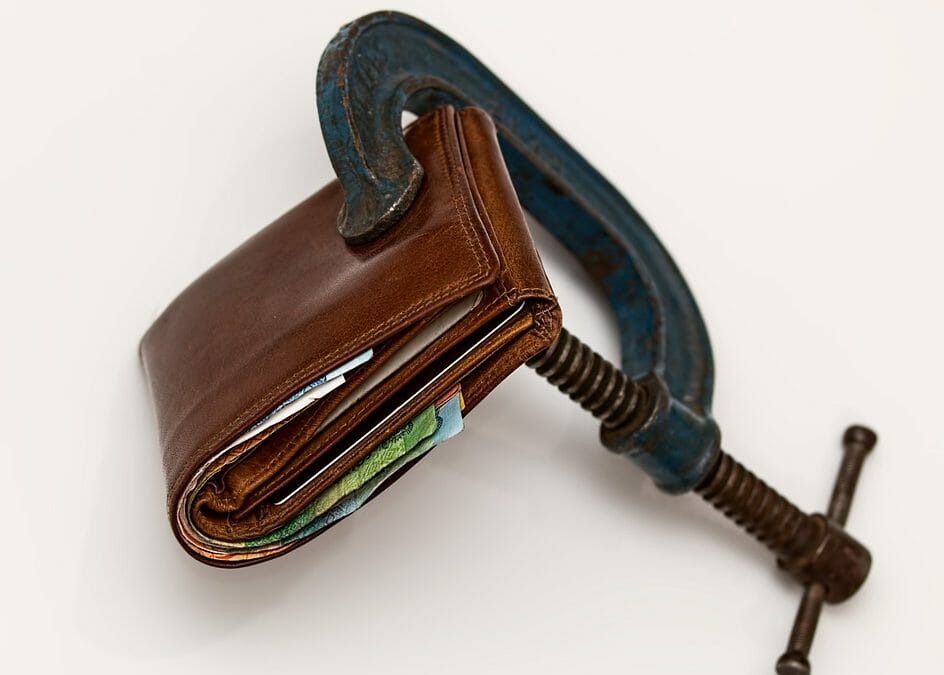 A wallet being squeezed by a C-Clamp.