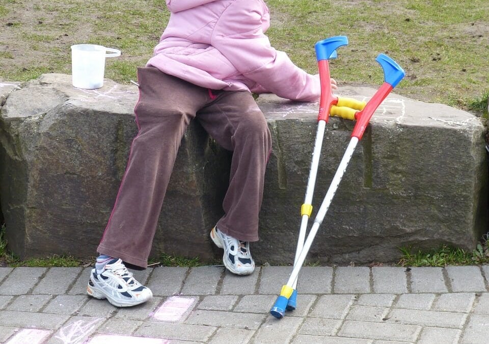 A small child with her crutches used to help her with her disabilities.