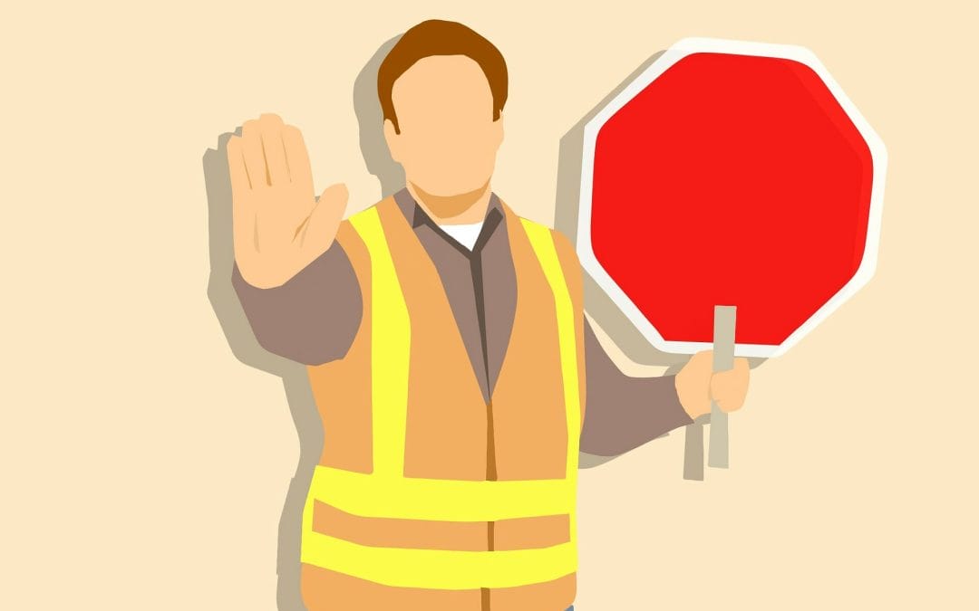An animation of a highway worker holding out their hand and holding up a stop sign in high visibility attire.